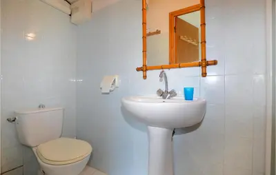 a bathroom with a toilet and a sink and a mirror at 1 Bedroom Lovely Apartment In Ghisoni in Ghisoni