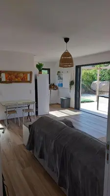 a bedroom with a bed and a kitchen with a refrigerator at Casa corsica in Pianottoli-Caldarello