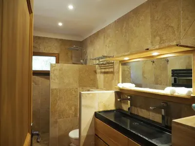 a bathroom with a sink and a toilet and a mirror at MAMMONA in Bonifacio