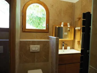 a bathroom with a sink and a toilet and a window at MAMMONA in Bonifacio