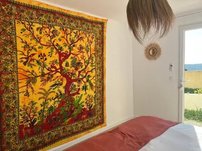 a large tapestry hanging on a wall in a bedroom at Villa Héliopolis in Ventiseri