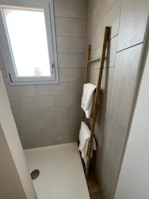 a bathroom with a shower with a toilet and towels at Villa Héliopolis in Ventiseri