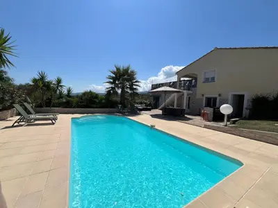 a swimming pool in front of a house at Villa Héliopolis in Ventiseri