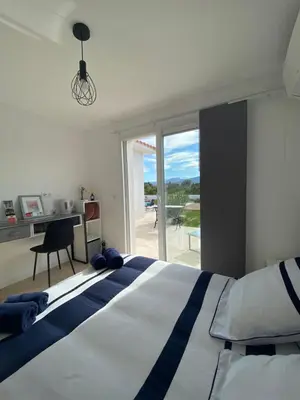 a bedroom with a bed and a desk and a window at Villa Vittoria in Ghisonaccia