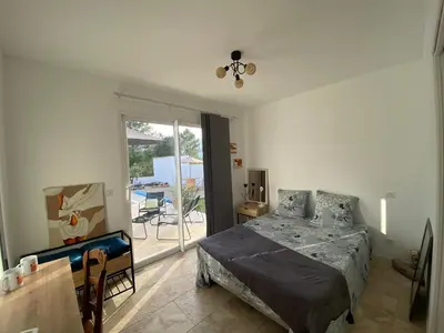 a bedroom with a bed and a sliding glass door at Villa Vittoria in Ghisonaccia
