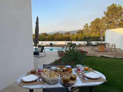 a table with food on it next to a pool at Villa Vittoria in Ghisonaccia