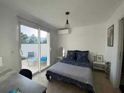 a bedroom with a bed and a sliding glass door at Villa Vittoria in Ghisonaccia