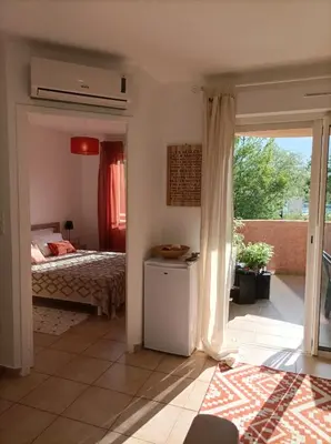 a kitchen with a wooden table and a microwave at Appartement T2 bord de mer/piscines in Moriani Plage