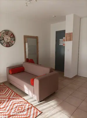 a living room with a couch and a table at Appartement T2 bord de mer/piscines in Moriani Plage
