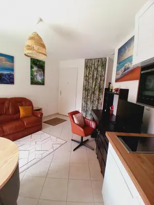 a living room with a couch and a large window at Appartement T2 bord de mer/piscines in Moriani Plage
