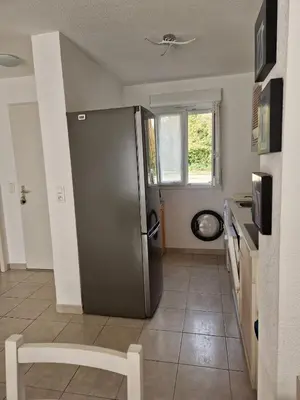 a kitchen with a stainless steel refrigerator and a window at VILLA MARYSABEL , maison T4 duplex, résidence villa de melody avec 2 piscines, mer à 500 m in Santa-Maria-Poggio
