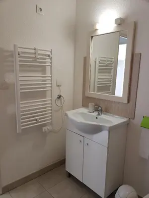 a bathroom with a white sink and a mirror at VILLA MARYSABEL , maison T4 duplex, résidence villa de melody avec 2 piscines, mer à 500 m in Santa-Maria-Poggio