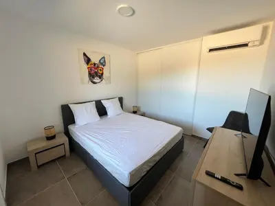 a bedroom with a bed and a desk with a television at T2 Porticcio neuf in Porticcio