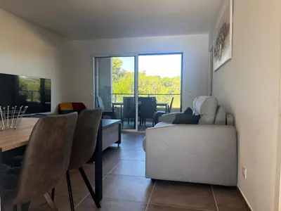 a living room with a couch and a table and a dining room at T2 Porticcio neuf in Porticcio