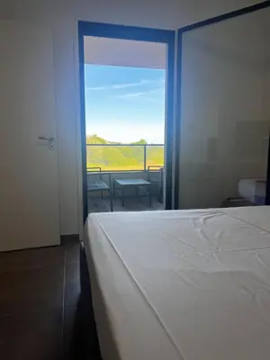 a bedroom with a bed and a sliding glass door at T2 Porticcio neuf in Porticcio