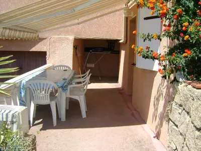 a patio with a table and chairs and flowers at Studio Olmeto in Olmeto