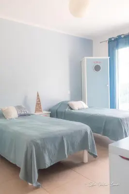 a room with two beds and a refrigerator at Grande villa de standing avec piscine à Sagone en Corse in Sagone