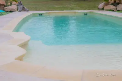 a swimming pool with blue water in a yard at Grande villa de standing avec piscine à Sagone en Corse in Sagone