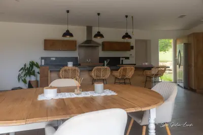 a kitchen and dining room with a wooden table and chairs at Grande villa de standing avec piscine à Sagone en Corse in Sagone