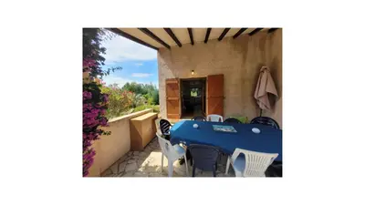 a patio with a blue table and chairs in a house at Plage Vardiola à pied Familiale 10 pers Corse Sud Porto Vecchio in Vardiola