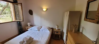 a bedroom with a bed with white sheets and a window at Plage Vardiola à pied Familiale 10 pers Corse Sud Porto Vecchio in Vardiola