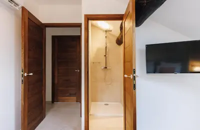 a bathroom with a shower and a television on a wall at A Macina in Porri