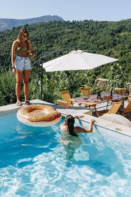 a woman standing next to a swimming pool with a person in the water at A Macina in Porri