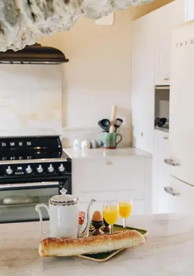 a kitchen counter with a tray with two glasses of orange juice at A Macina in Porri