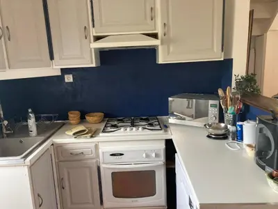 a kitchen with white cabinets and a stove top oven at L’Attellu in Feliceto