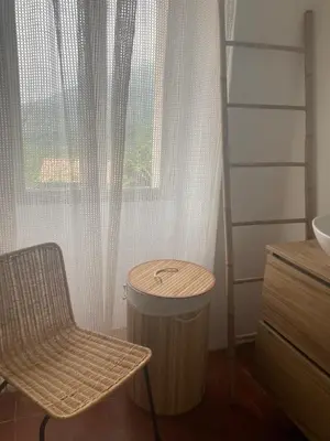 a bathroom with a chair and a table and a window at L’Attellu in Feliceto