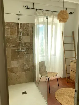a glass shower with a chair in a room at L’Attellu in Feliceto