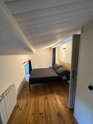 a bedroom with a bed and a wooden floor at L’Attellu in Feliceto