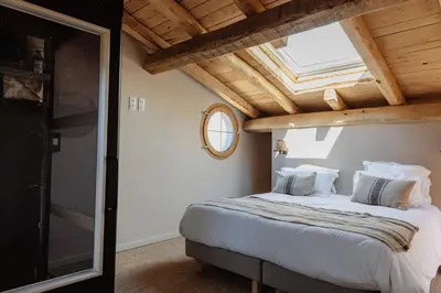 a bedroom with a large bed with a skylight at Bergerie face à Propriano in Fozzano