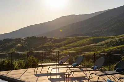 a deck with chairs and a view of a mountain at Bergerie face à Propriano in Fozzano