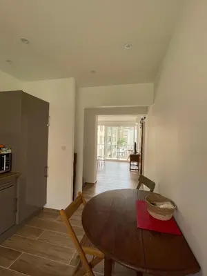 a dining room with a table and a kitchen at Appartement T3 neuf centre ville in Ajaccio