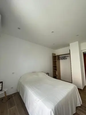 a bedroom with a white bed in a room at Appartement T3 neuf centre ville in Ajaccio