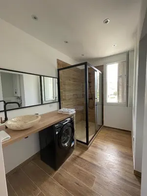 a bathroom with a washing machine and a mirror at Appartement T3 neuf centre ville in Ajaccio