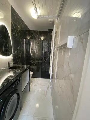 a bathroom with a washer and dryer in at Grand T2 Cours Napoleon B in Ajaccio