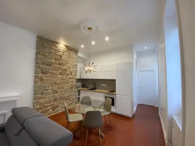 a living room with a couch and a table and chairs at Grand T2 Cours Napoleon B in Ajaccio