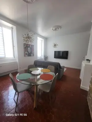 a living room with a table and a couch at Grand T2 Cours Napoleon B in Ajaccio
