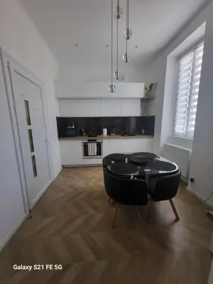 a living room with a table and a kitchen at Grand T2 Cours Napoleon B in Ajaccio