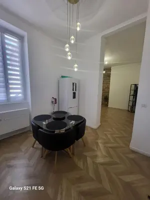 a living room with a black table and a refrigerator at Grand T2 Cours Napoleon B in Ajaccio