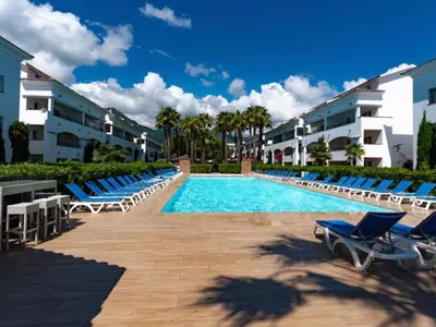 a swimming pool with blue lounge chairs and buildings at Vacances en Corse in San-Nicolao
