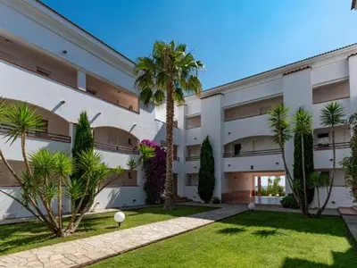 a large building with palm trees in front of it at Vacances en Corse in San-Nicolao