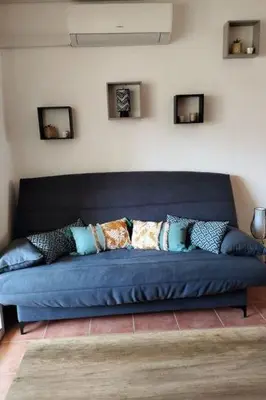 a blue couch with pillows on it in a room at Vacances en Corse in San-Nicolao