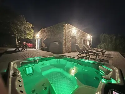 a green bath tub in front of a house at night at Villa 2 chambres avec jacuzzi in Bonifacio