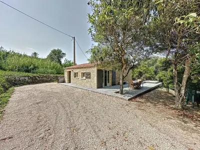 a house on a dirt road with a building at Villa 2 chambres avec jacuzzi in Bonifacio