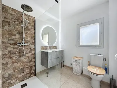 a bathroom with a shower and a toilet and a sink at Villa 2 chambres avec jacuzzi in Bonifacio