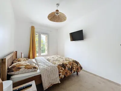 a bedroom with a bed and a television on the wall at Villa 2 chambres avec jacuzzi in Bonifacio
