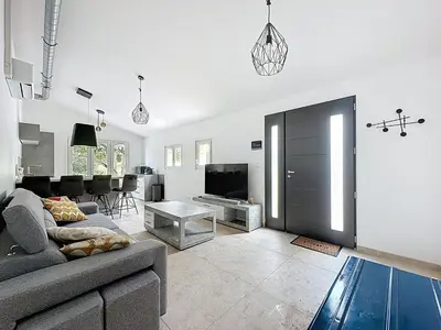 a living room with a couch and a tv at Villa 2 chambres avec jacuzzi in Bonifacio